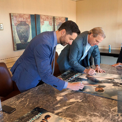 Mandeville Films EP Todd Lieberman signing Insurgent posters with co-producer Douglas Wick.